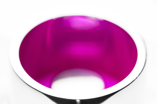a magenta coloured object encircled by silver surfaces.